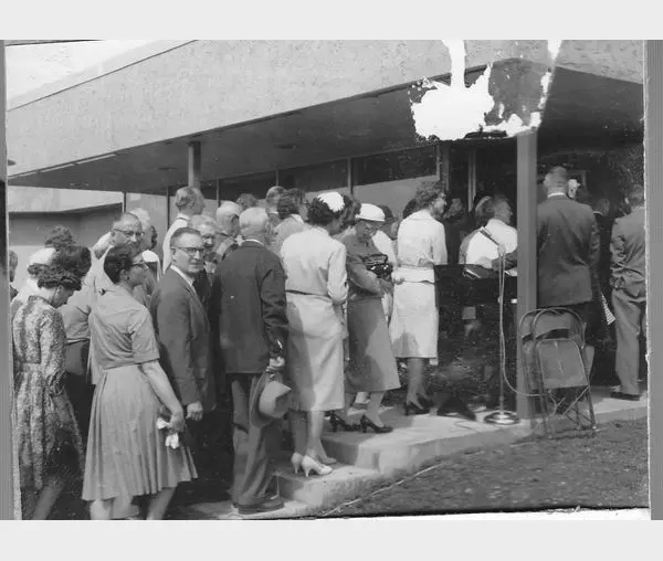 A group of people standing around in front of a building.