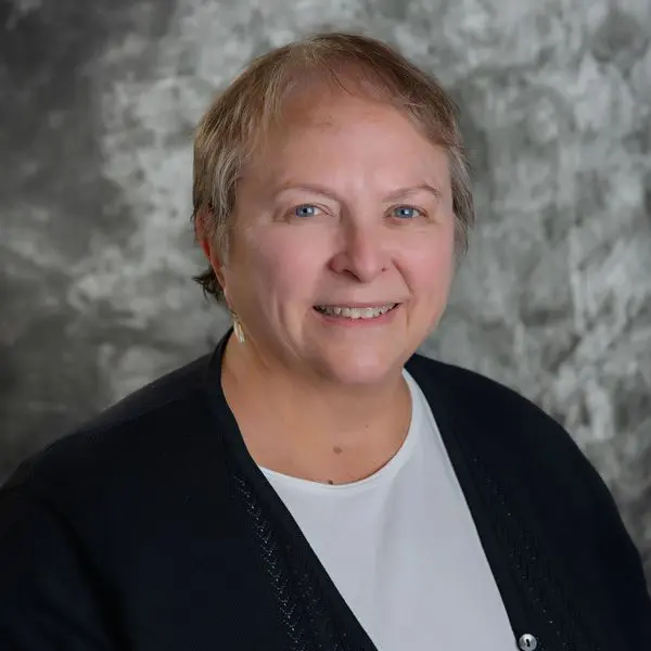 A woman with short hair is smiling for the camera.